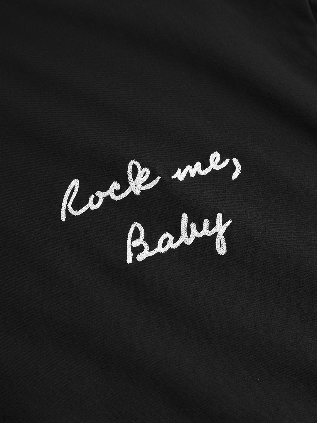 Detail van de geborduurde “Rock me, baby” tekst op het DWC t-shirt