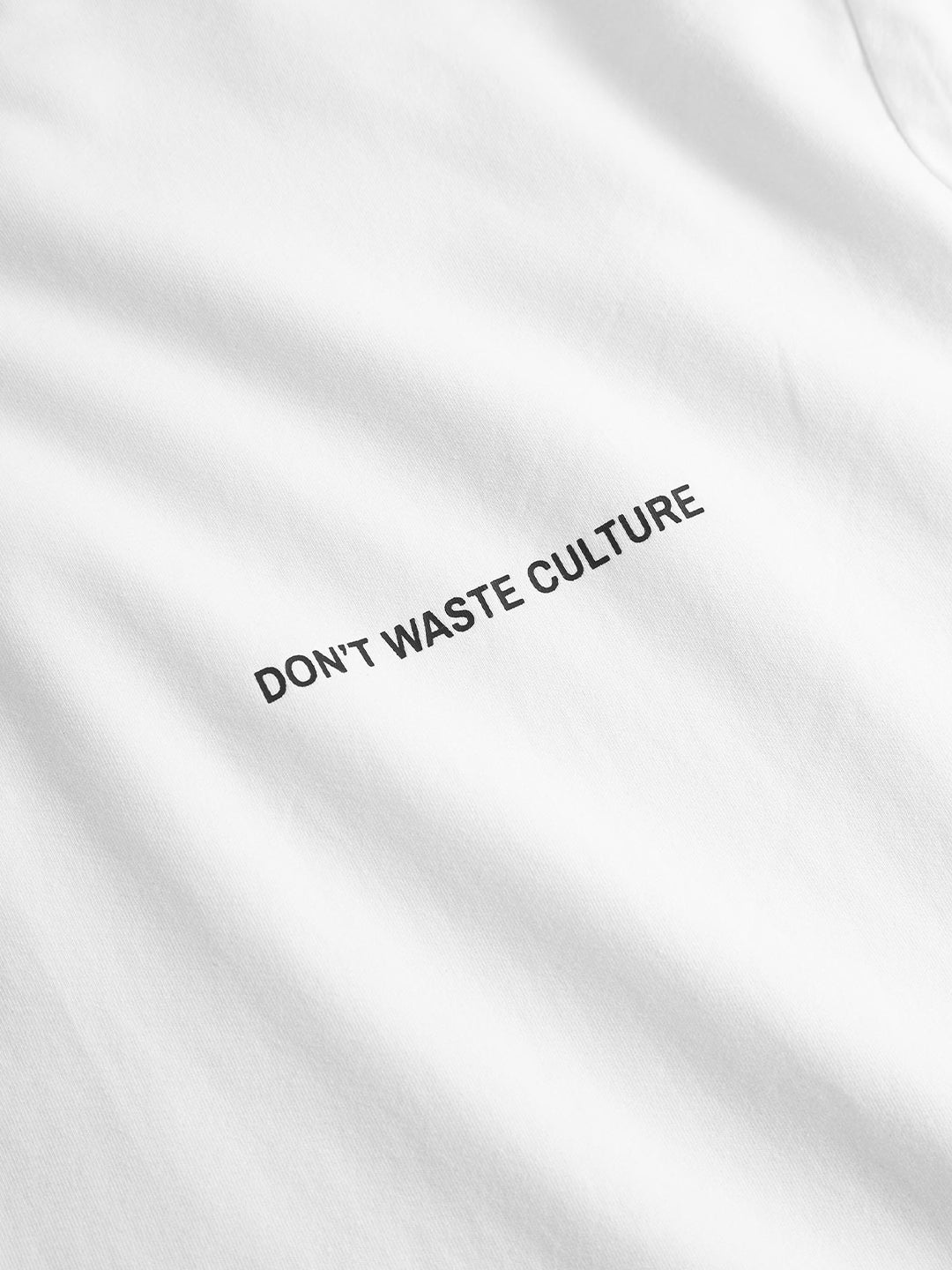 Close-up van het DWC-logo op de borst van het Calyra T-Shirt