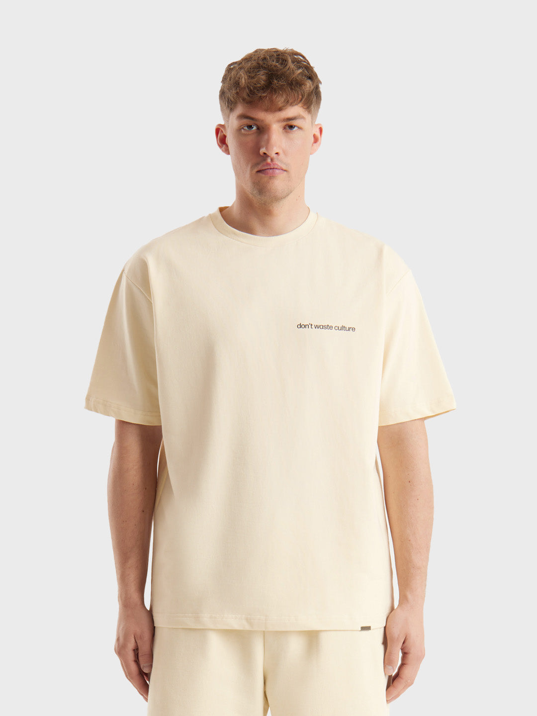 Model draagt Cleo T-shirt in beige, met kleine borstbranding