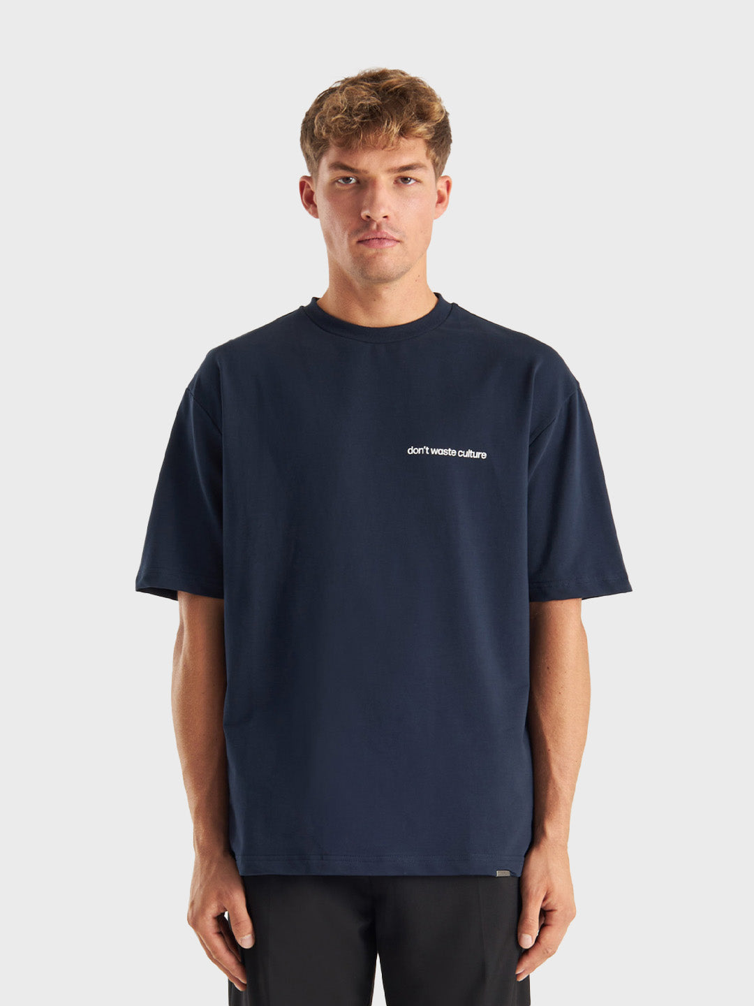 Model draagt Cleo T-shirt in Navy, met kleine borstbranding