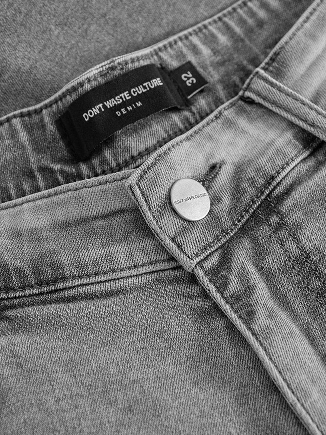 Close-up van denim, knoopsluiting en DWC patch