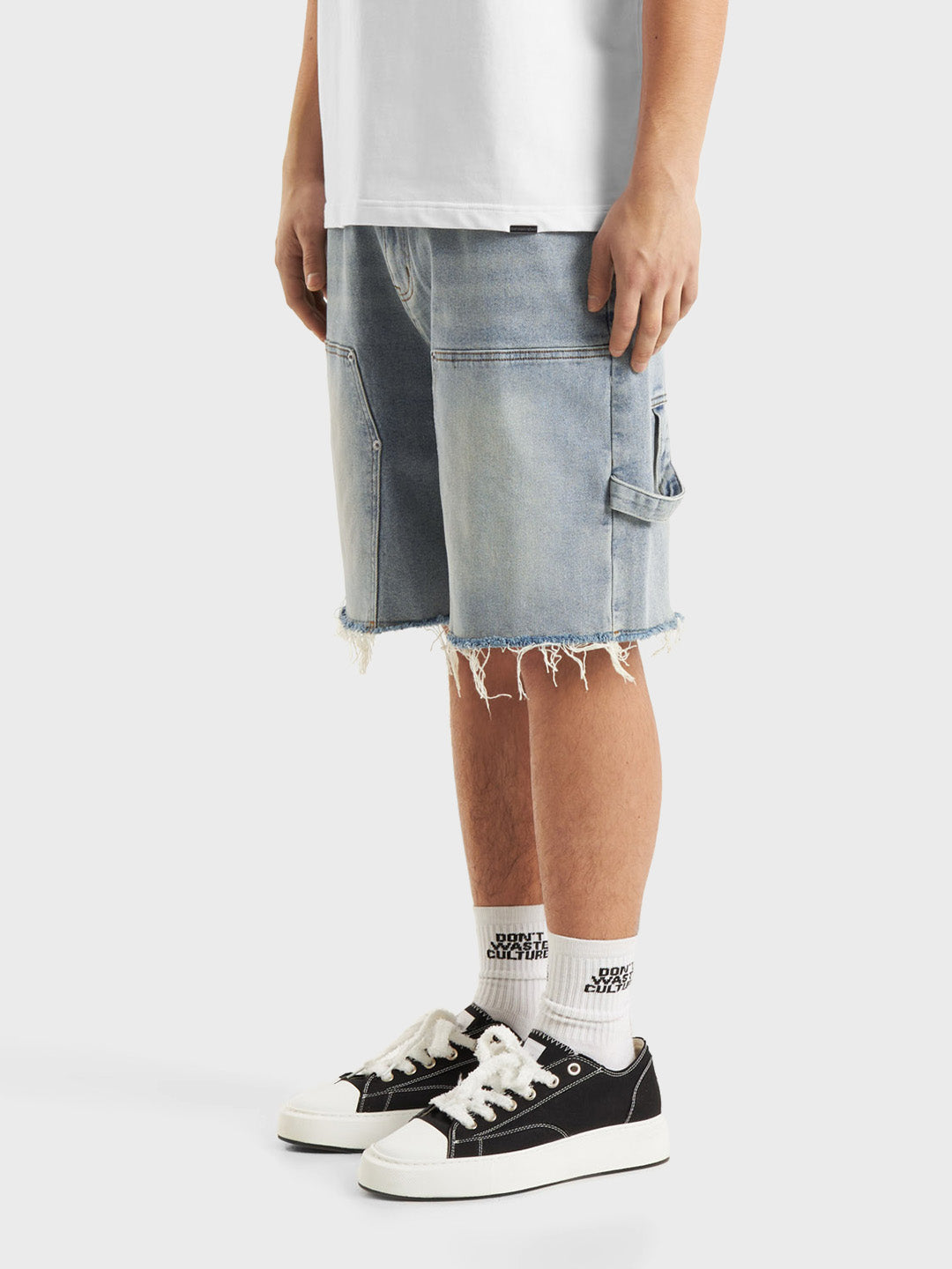 Model draagt DWC Nolara Denim Shorts Light Blue – Schuin vooraanzicht