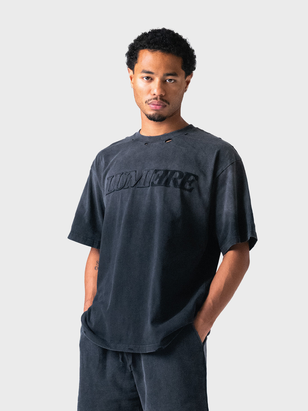 Schuin vooraanzicht van het zwarte oversized shirt van Lumi3re