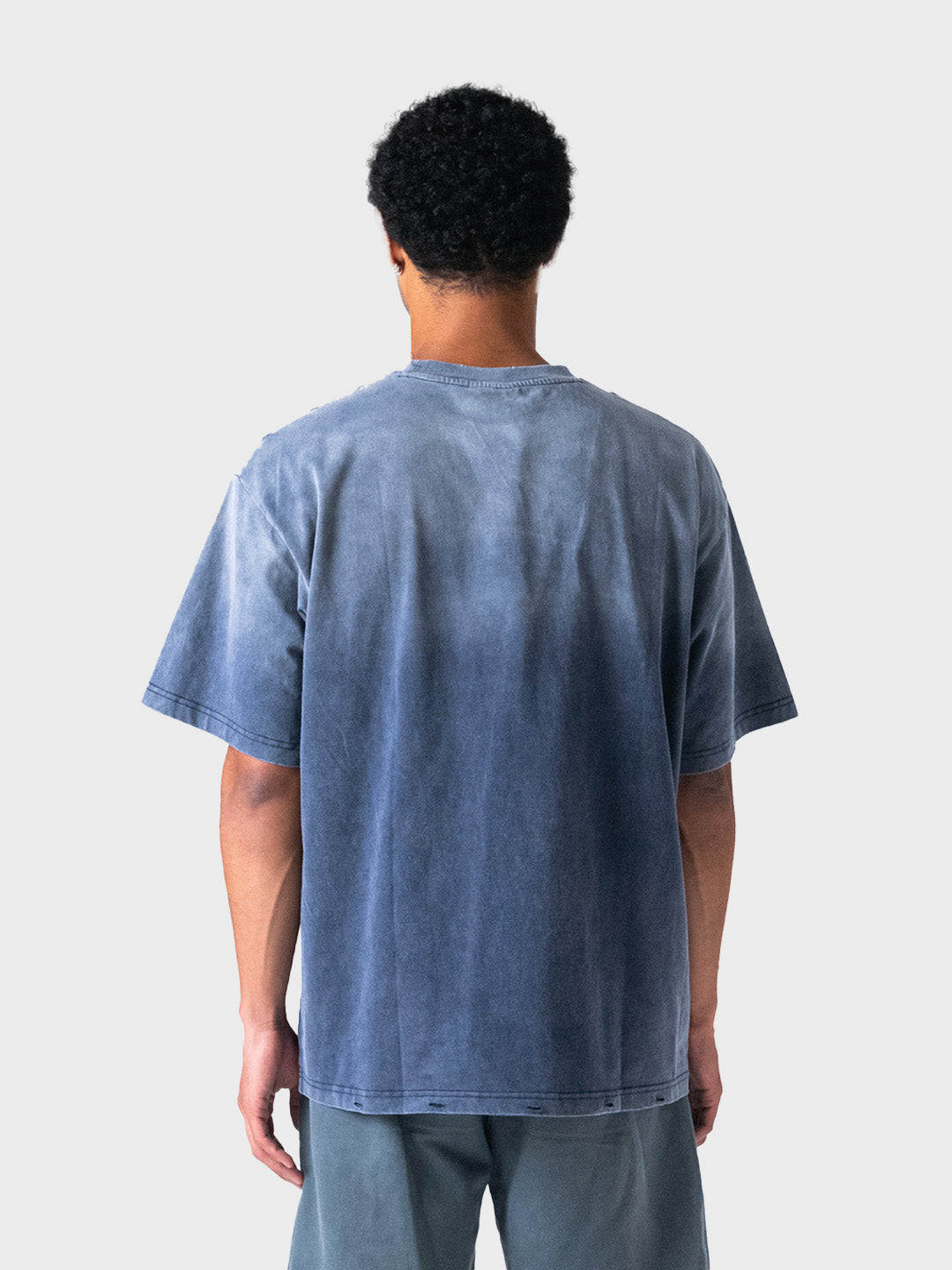 Achterkant model met gewassen blauw Lumi3re T-shirt