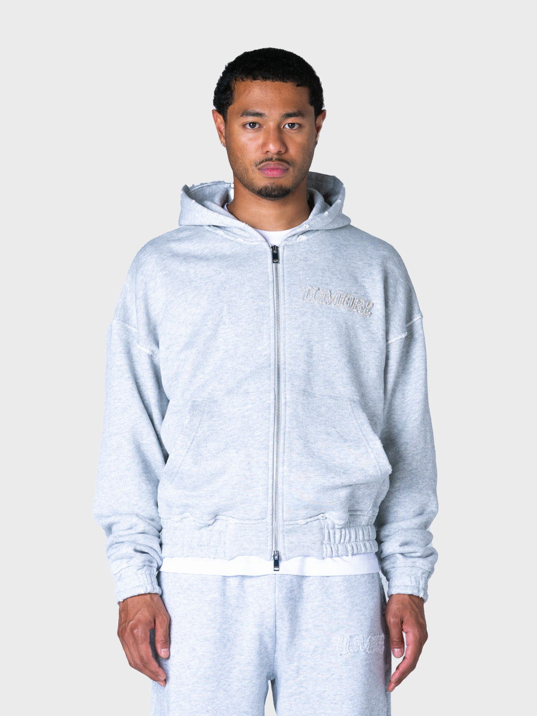 Model draagt grijze Lumi3re hoodie met rits, voorkant