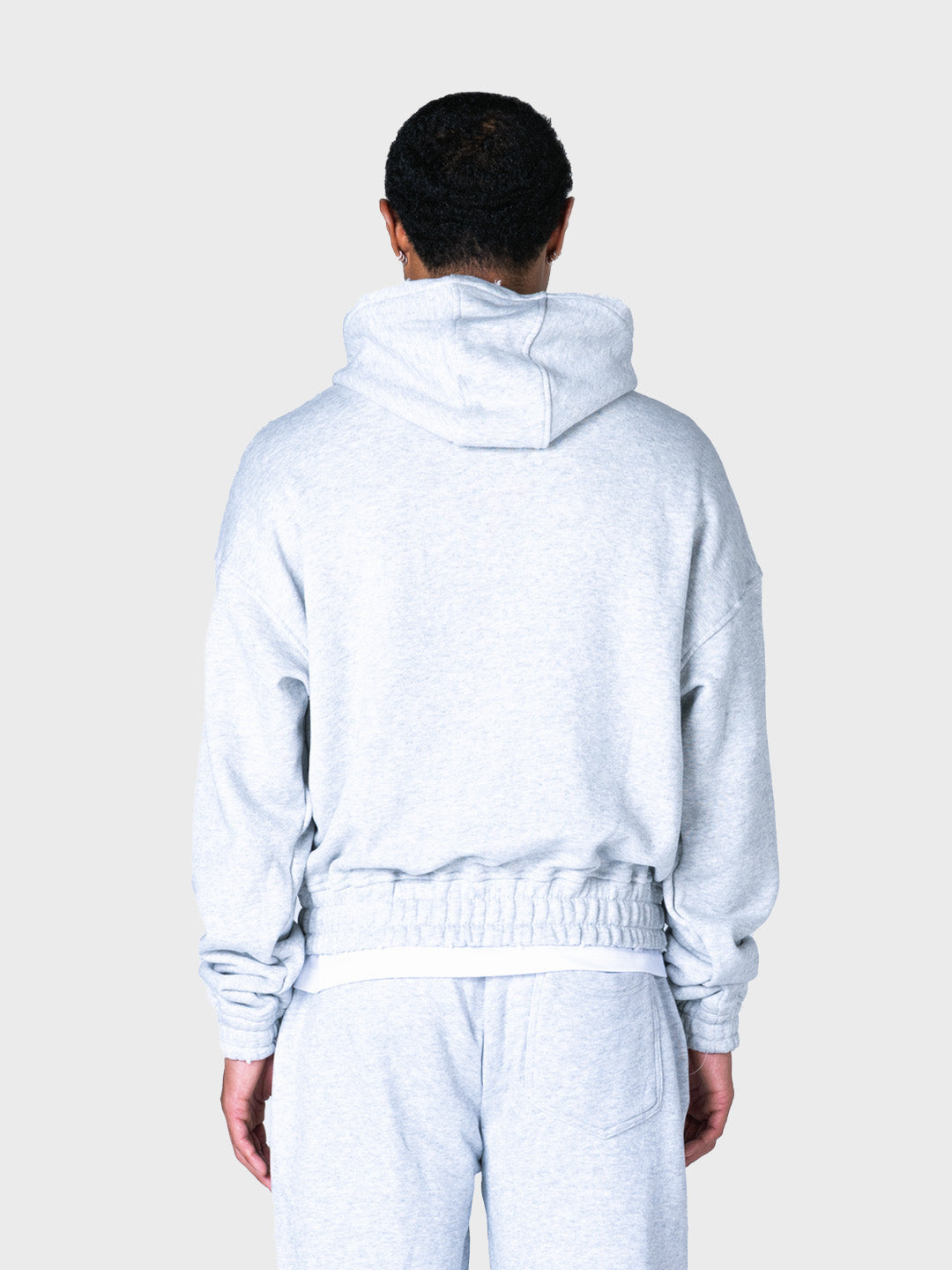 Model draagt grijze Lumi3re hoodie met rits, achterkant
