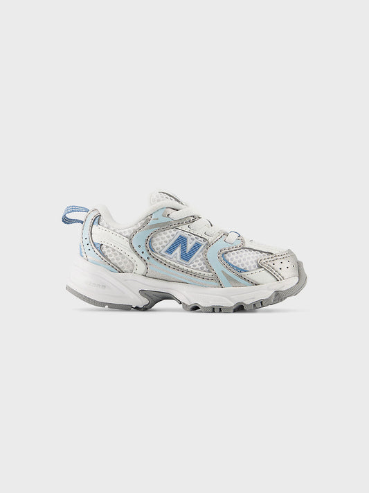 Zijaanzicht van de New Balance 530 kindersneaker in wit en lichtblauw