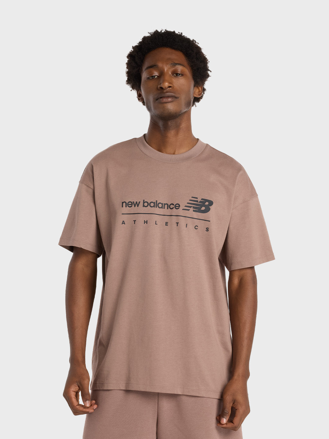 Model draagt bruin New Balance t-shirt met zwarte graphic