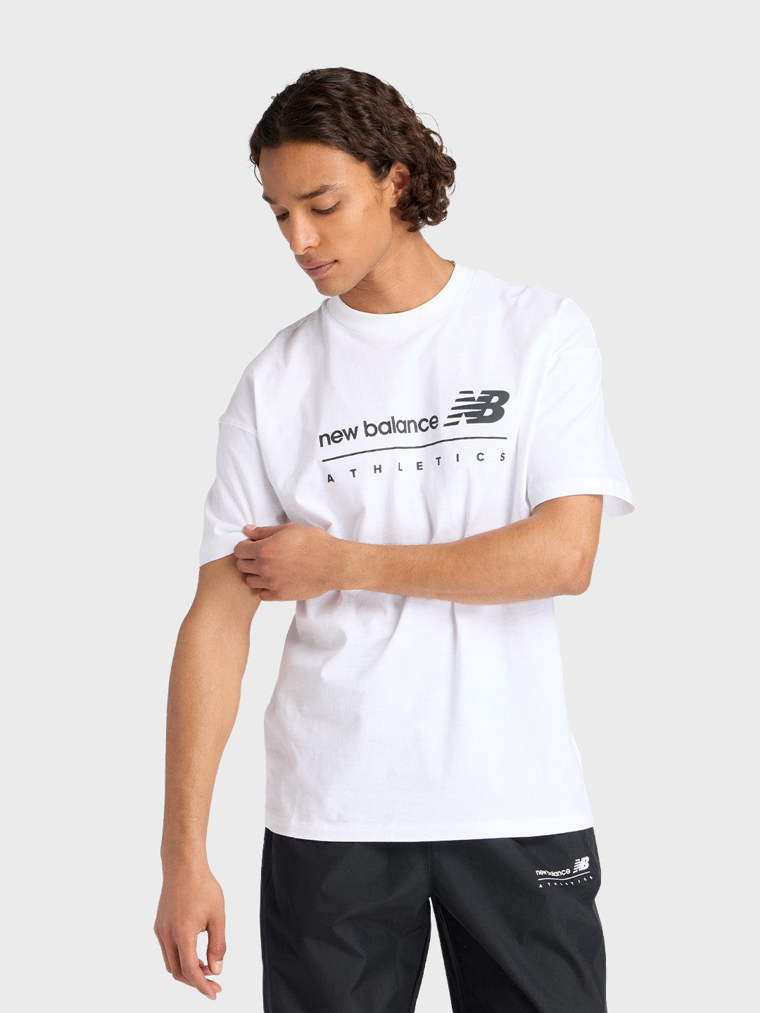 Model draagt wit New Balance t-shirt met zwarte graphic