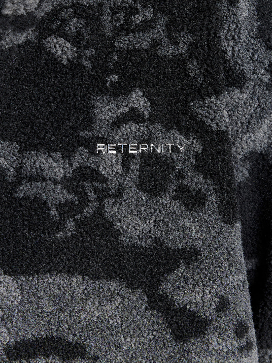 Reternity Fleece Jacket Acid Black – close-up van metalen brandingdetail