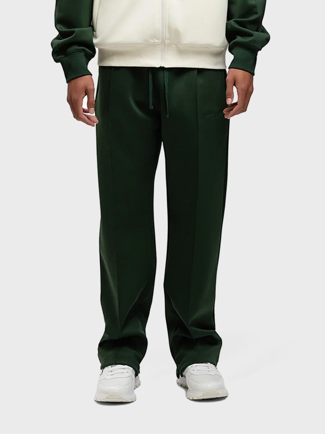 Model draagt de Rivero Atelier Track Pants in groen – vooraanzicht