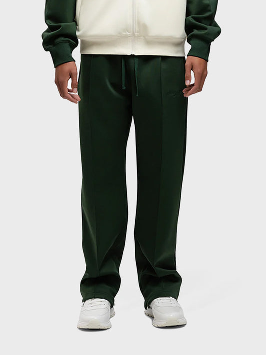 Model draagt de Rivero Atelier Track Pants in groen – vooraanzicht