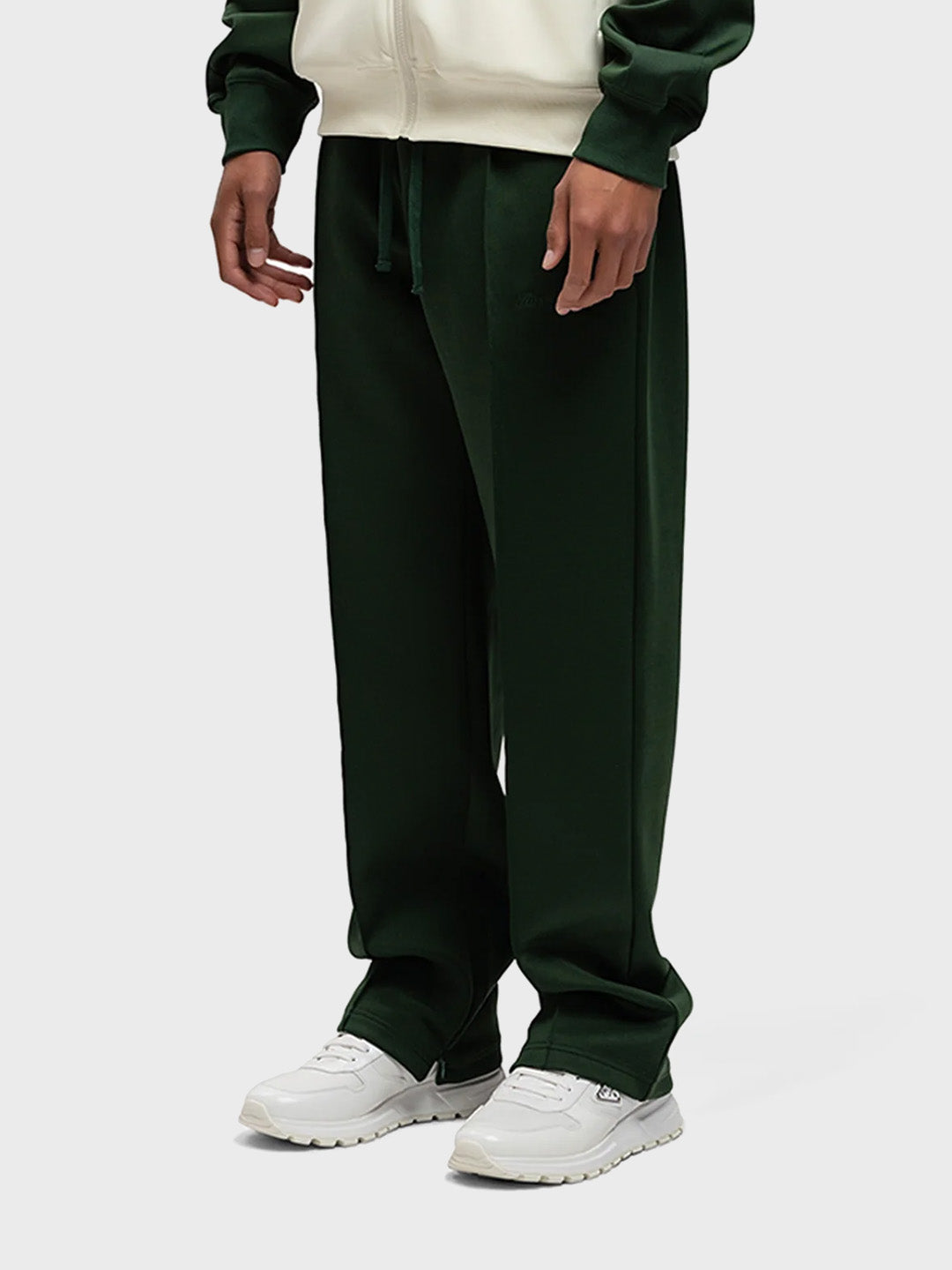 Schuin aanzicht van de track pants met zichtbare ritsdetails
