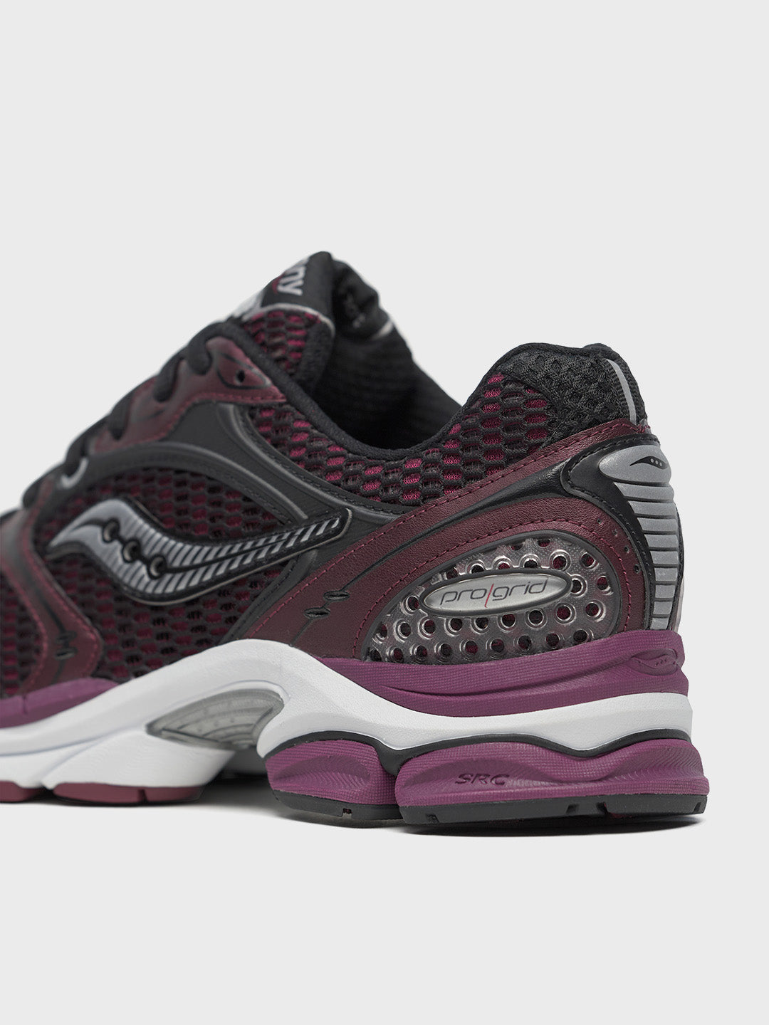 Close-up hiel met Saucony branding in zwart op bordeauxrood bovenwerk