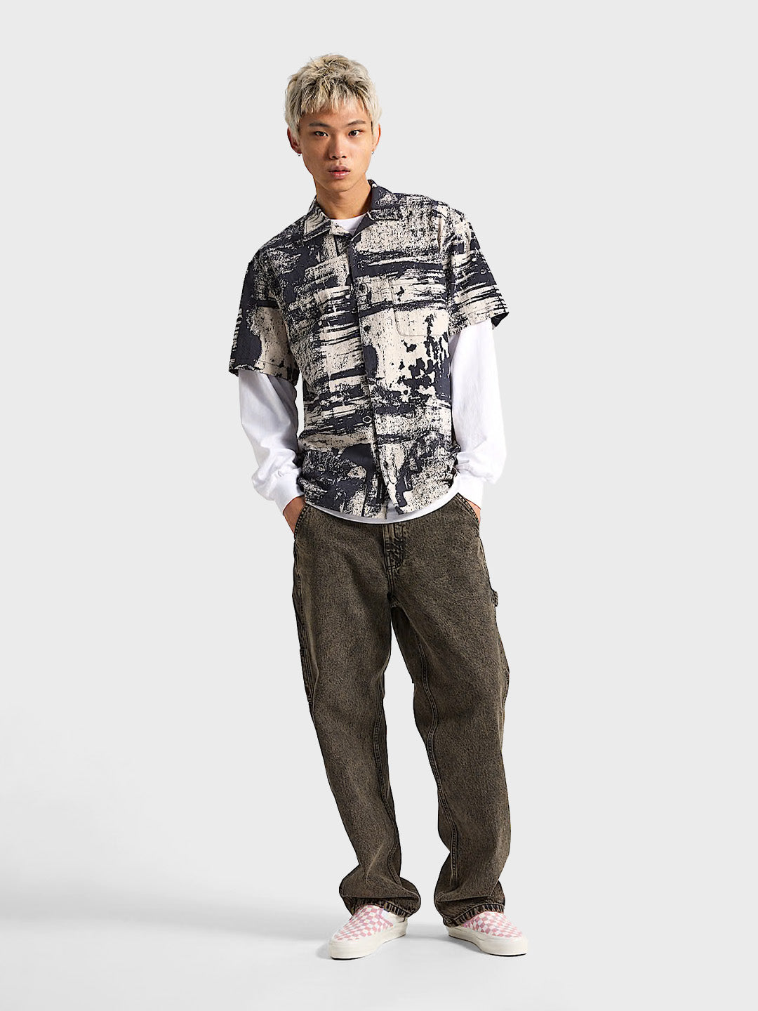 Model combineert Vans overhemd met longsleeve en baggy jeans