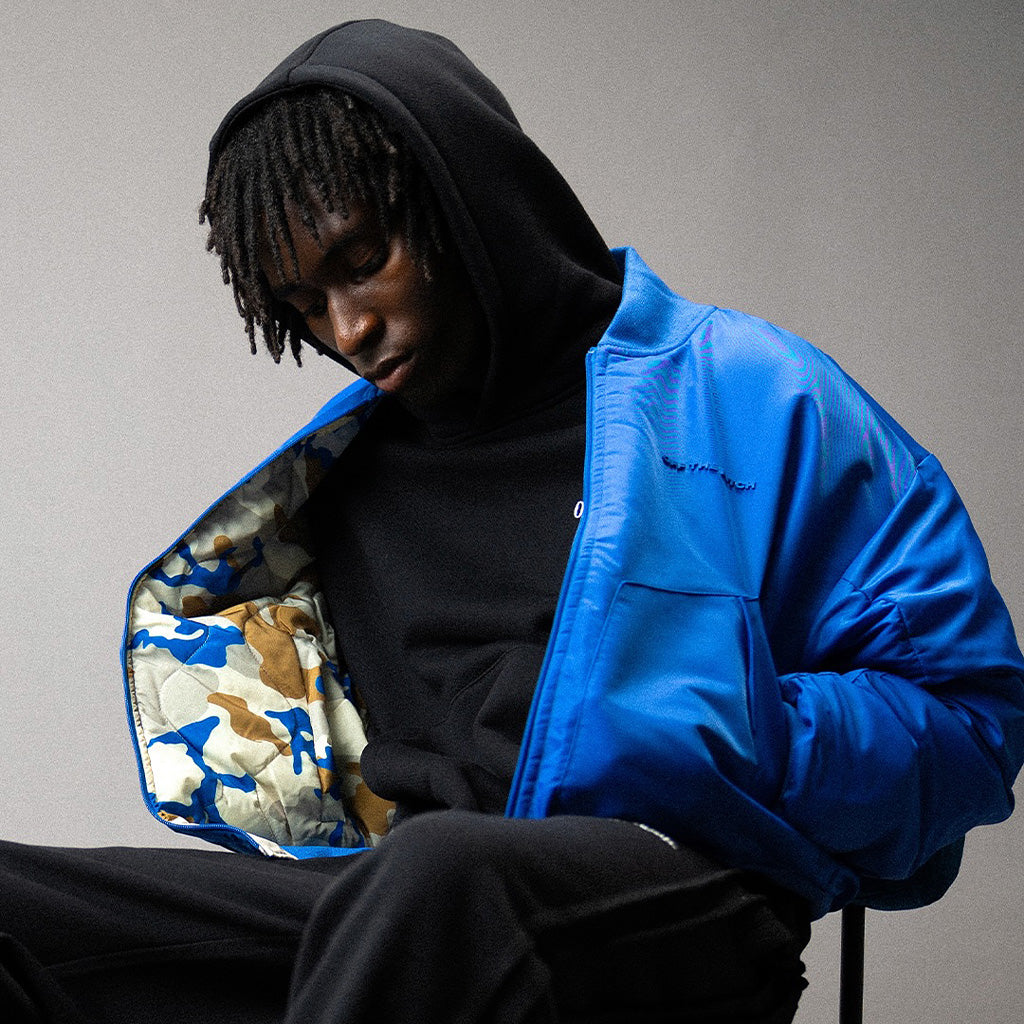 Model draagt Off The Pitch oversized hoodie en jacket – premium streetwear met sportieve invloeden.