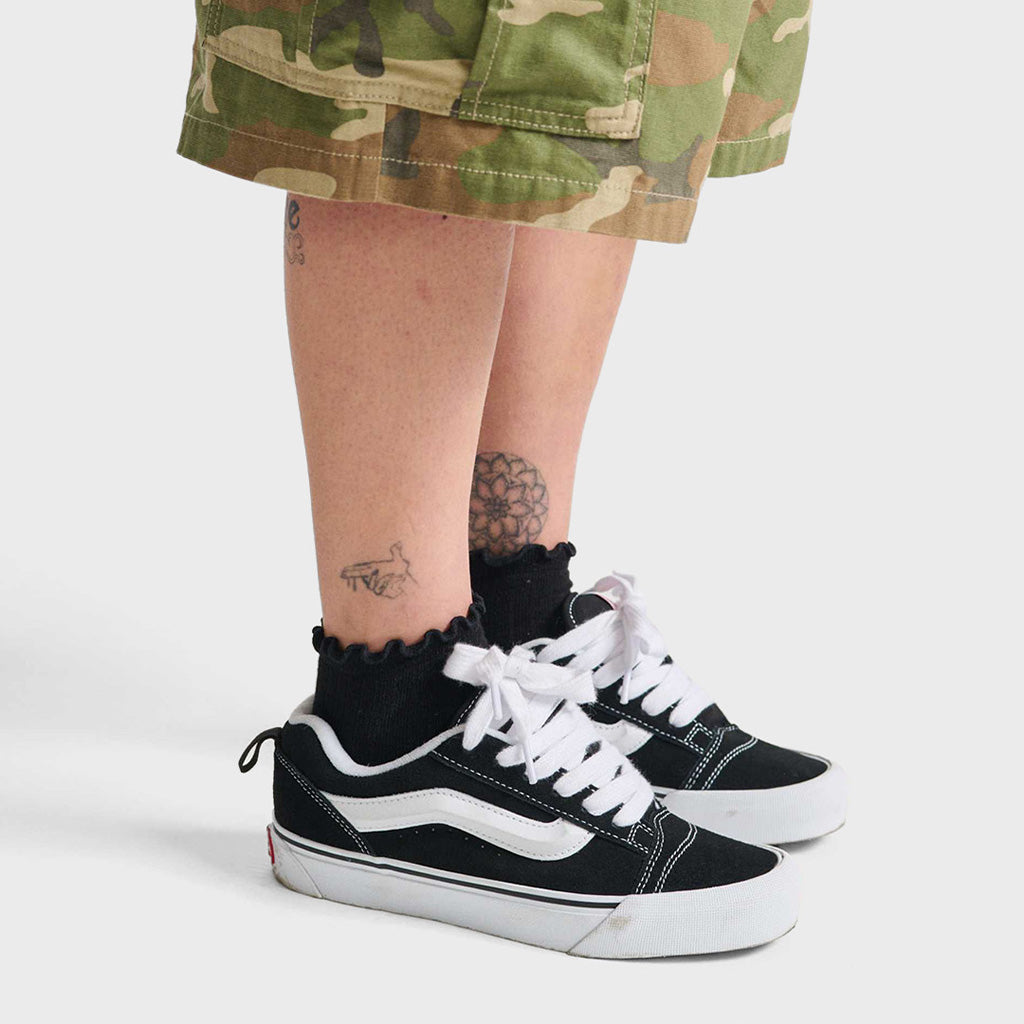 Model draagt Vans Knu Skool sneakers. Bulky Vans schoenen met dikke veters