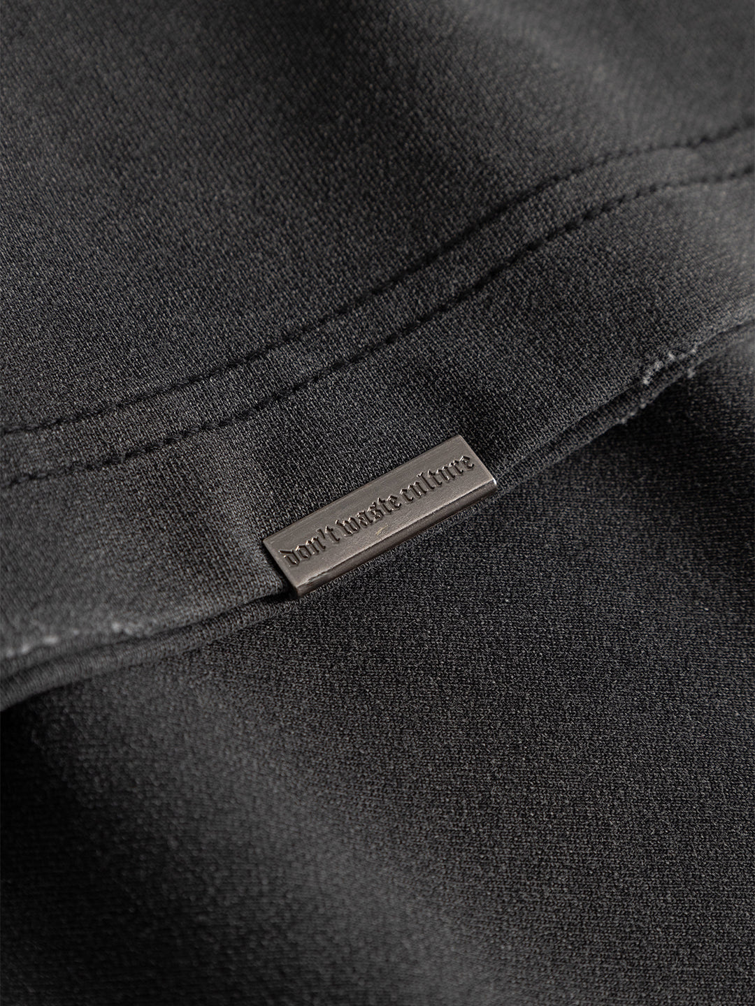 Close-up stof en metalen label Don’t Waste Culture Azemari T-Shirt Washed Black