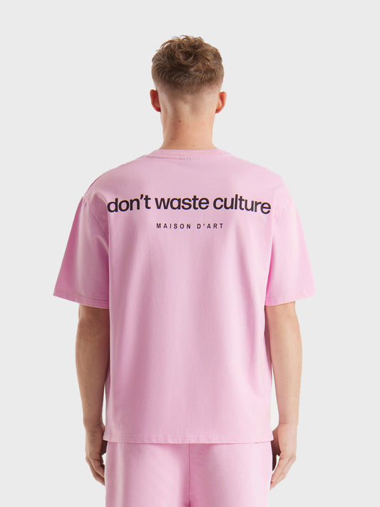 Model draagt Don’t Waste Culture Cleo T-shirt in Pink, rugzijde zichtbaar met grote graphic