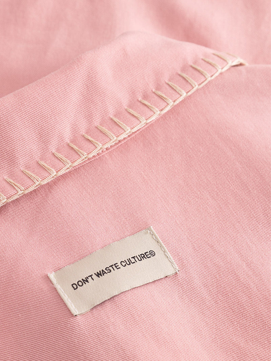 Close-up geborduurde boord en label – DWC Giran Shirt Pink