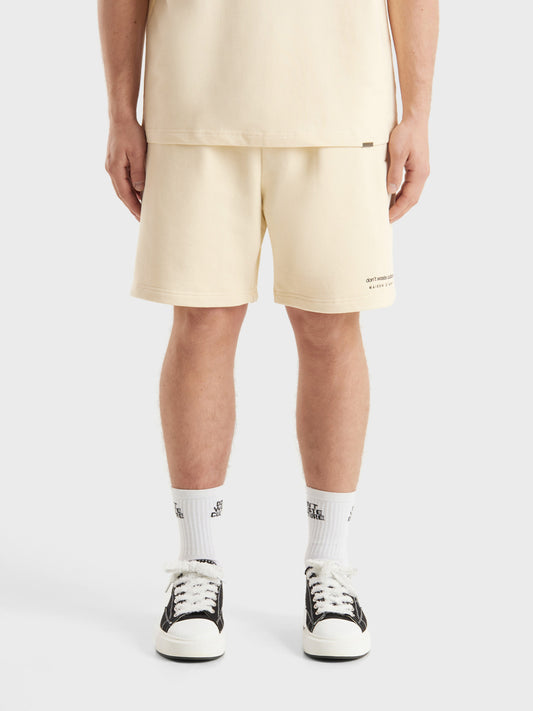 Model draagt DWC Jerr shorts in beige, front view