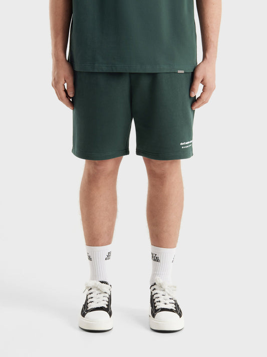 Model draagt DWC Jerr shorts in Dark Green, front view