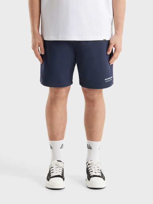 Model draagt DWC Jerr shorts in Navy, front view