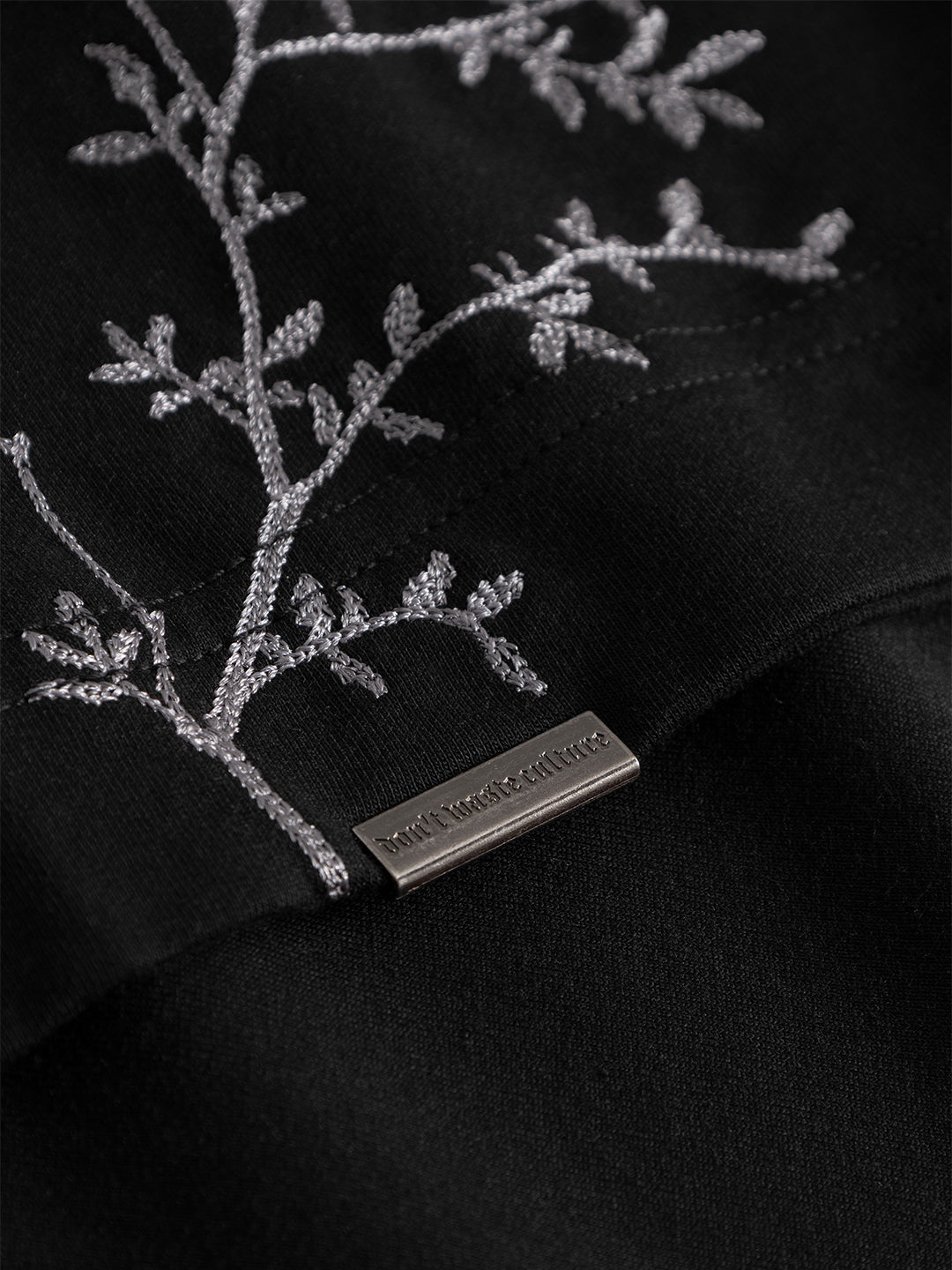 Close-up geborduurde olijftakken en metalen label Morikae T-Shirt Black