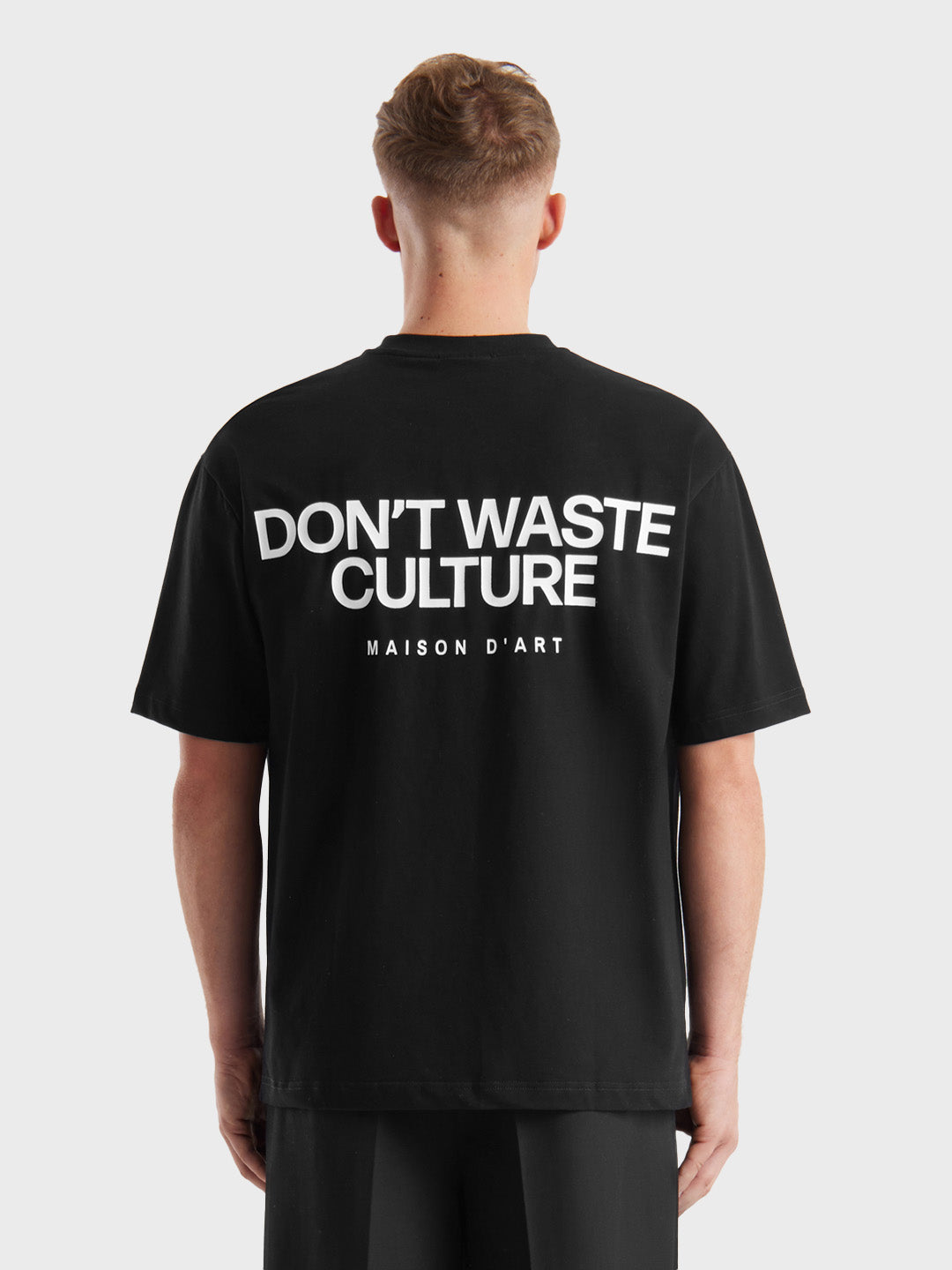 Backprint zichtbaar van het zwarte Don’t Waste Culture Tirion T-shirt, gedragen door model.