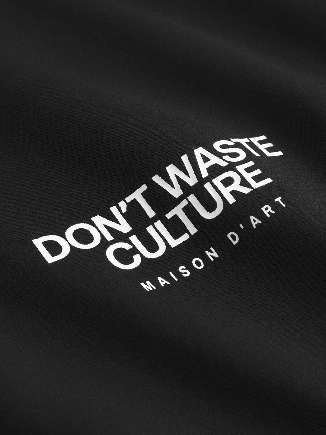 Close-up van de graphic op het zwarte Tirion T-shirt van Don’t Waste Culture.
