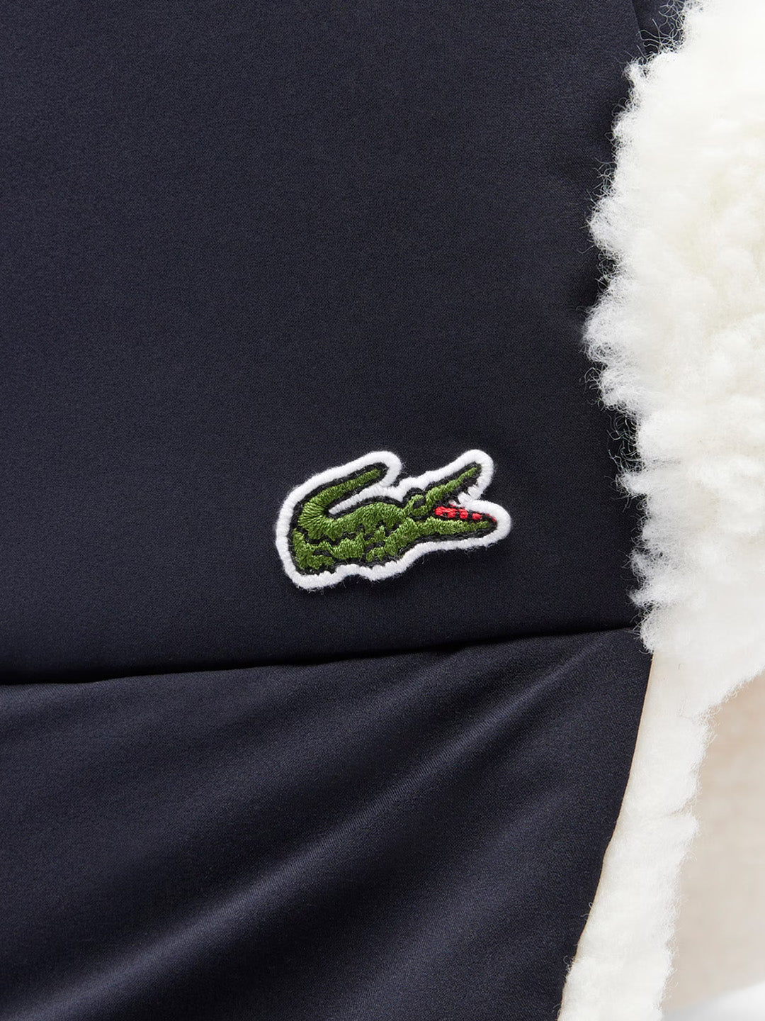 Close-up Lacoste krokodil logo op beanie