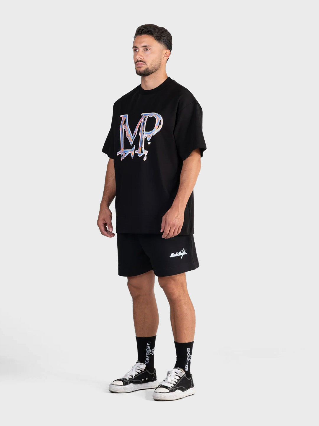 Le Monde Perdu Leaking Logo T-Shirt Black oversized fit graphic tee schuin voor Reloadstore