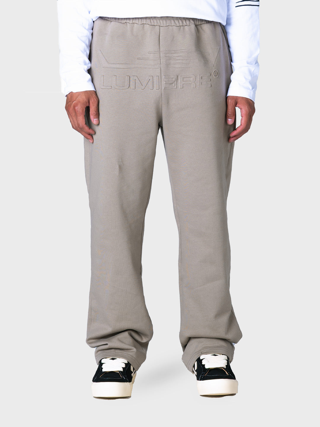 Model draagt Lumi3re Fly Logo Pants in beige, voorkant