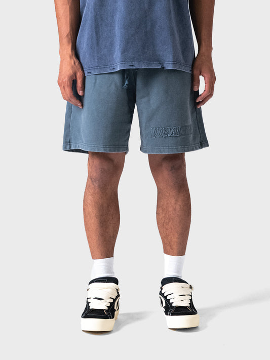 Model draagt Lumi3re shorts in Washed Blue, voorkant