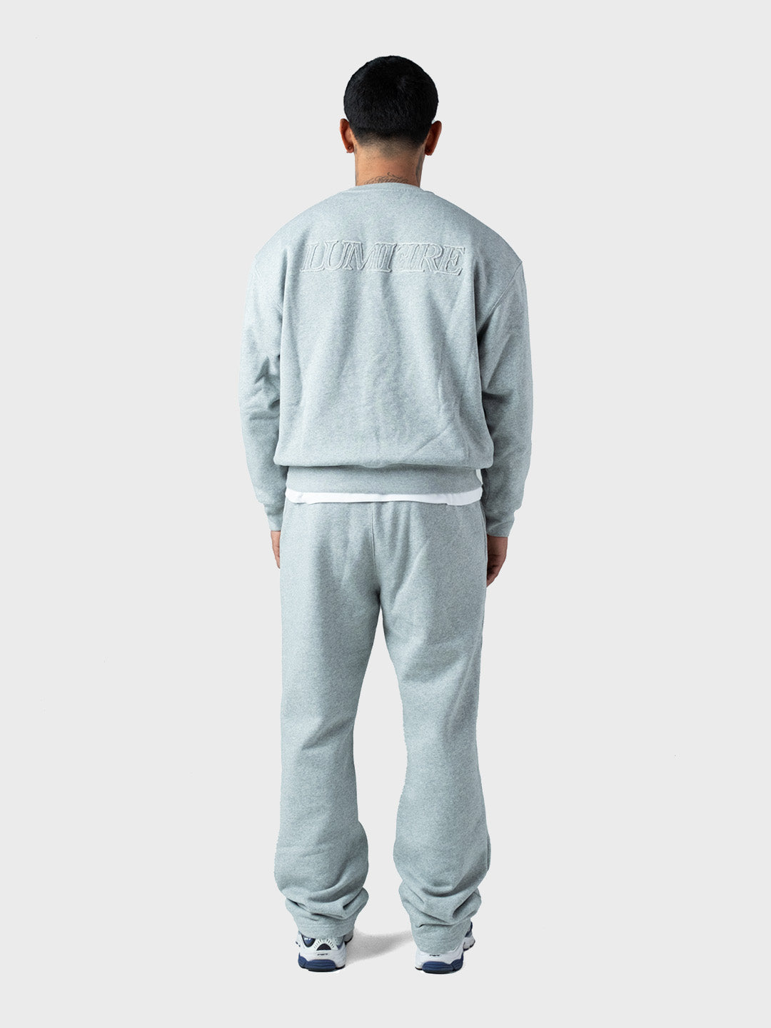 model achterkant met grijs Lumi3re tracksuit