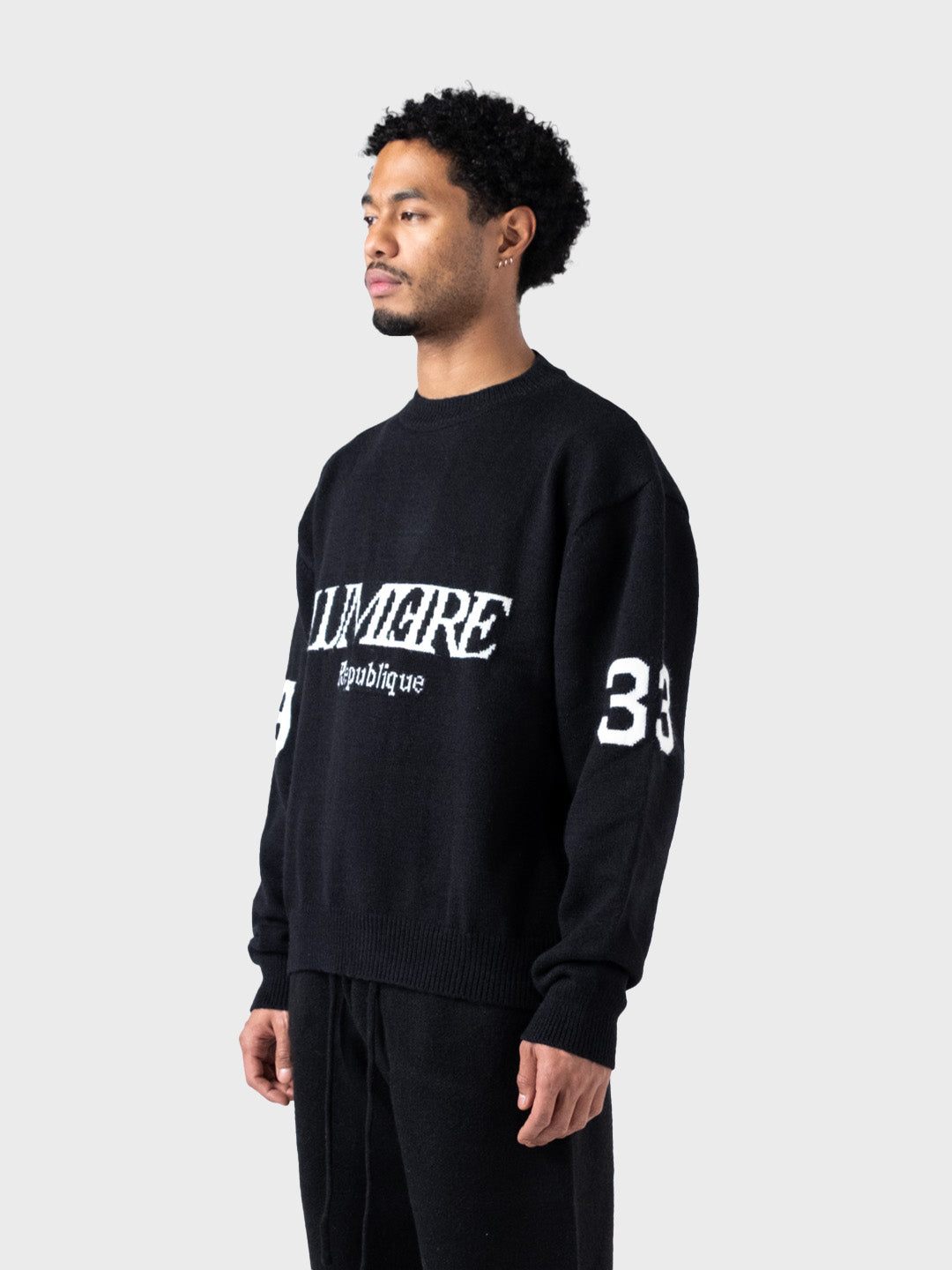Model draagt Lumi3re Republique 1933 Knitted Sweater Black – schuin vooraanzicht