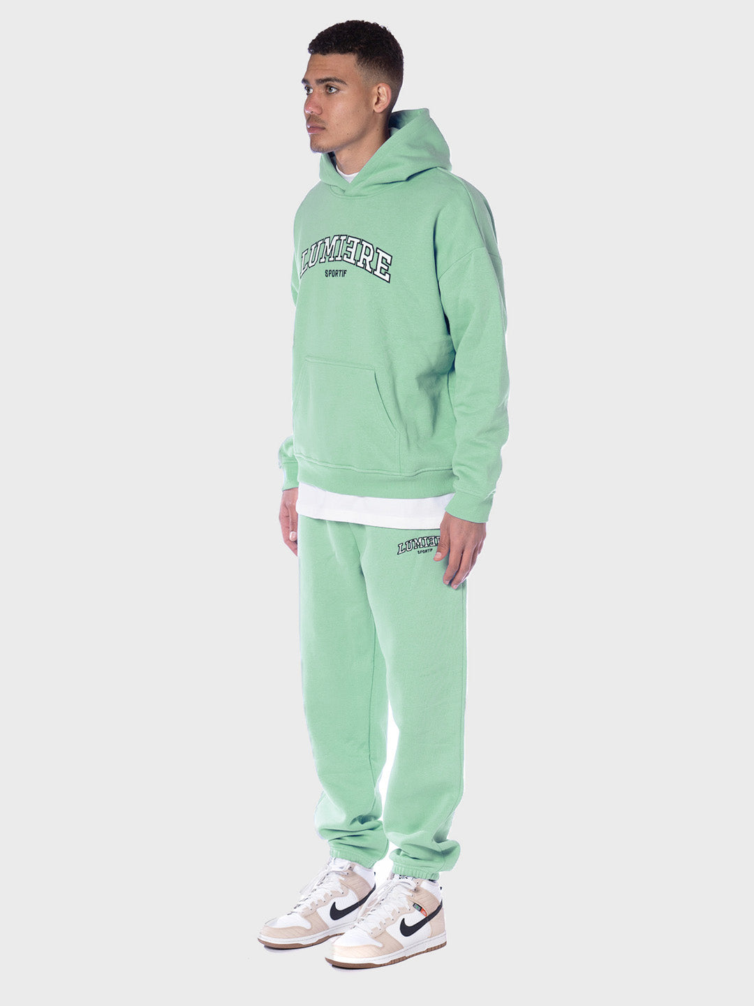 model schuin voor met tracksuit in light green