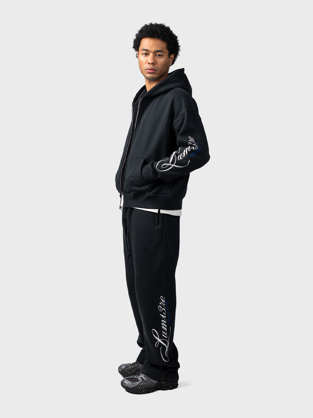 Lumi3re Toujours Zipper Tracksuit Black – model schuin vooraanzicht