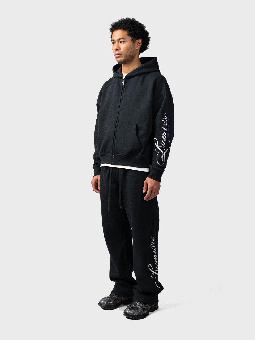 Lumi3re Toujours Zipper Tracksuit Black – model zijkant, set zichtbaar