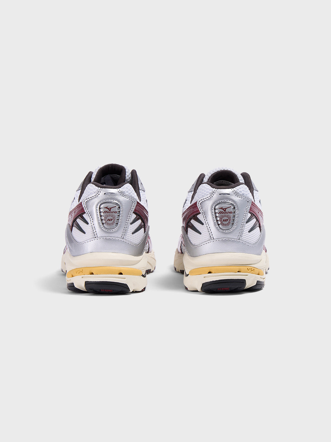 Achteraanzicht van de Mizuno Wave Rider 10 sneakers in wit/rood