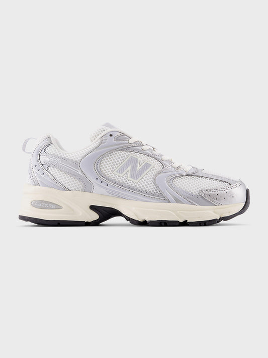 Zijaanzicht van de New Balance 530 in wit met zilveren en lila accenten