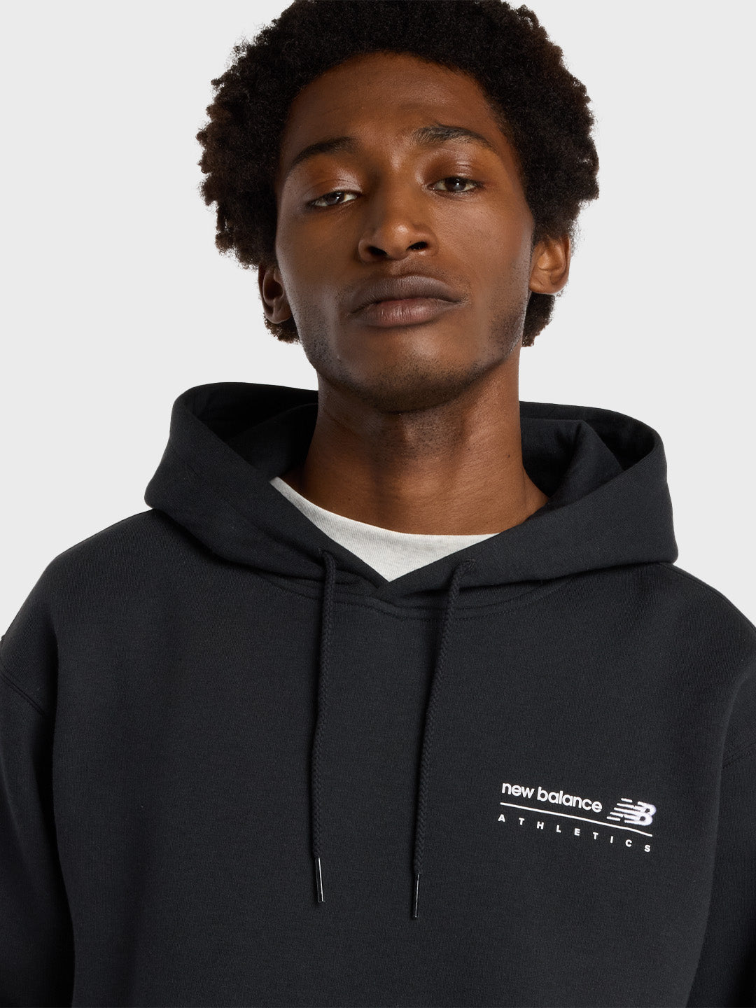 Close-up van borstlogo en capuchon van de zwarte NB hoodie