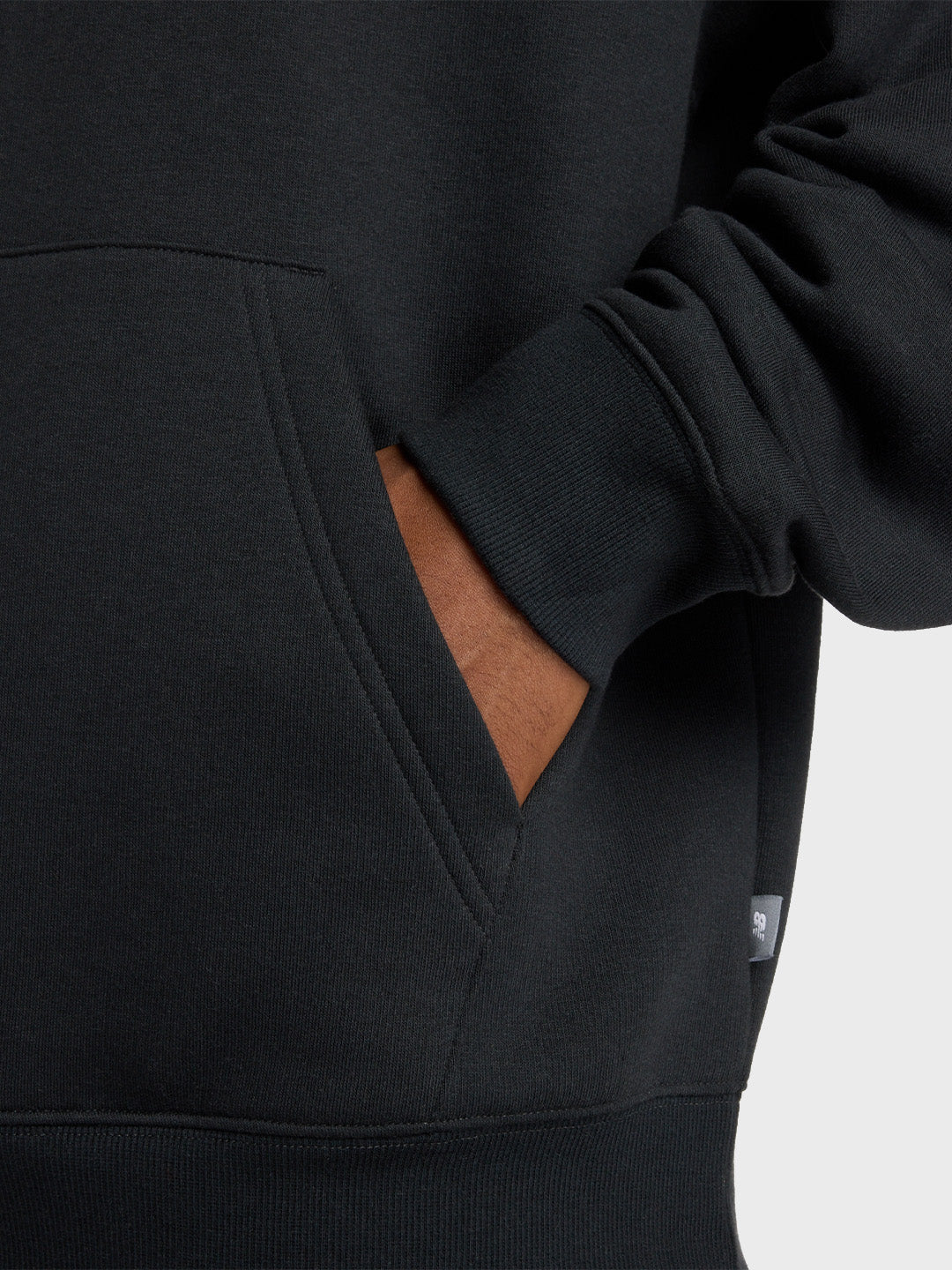Detail van de kangoeroezak aan de voorkant van de New Balance hoodie