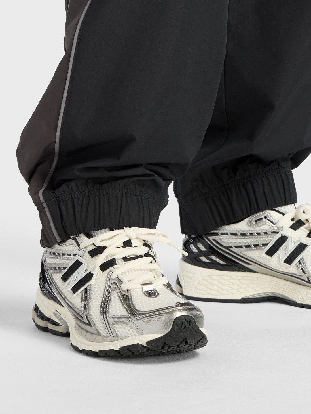 New Balance Trackside Pants Black close-up elastische zoom bij enkel