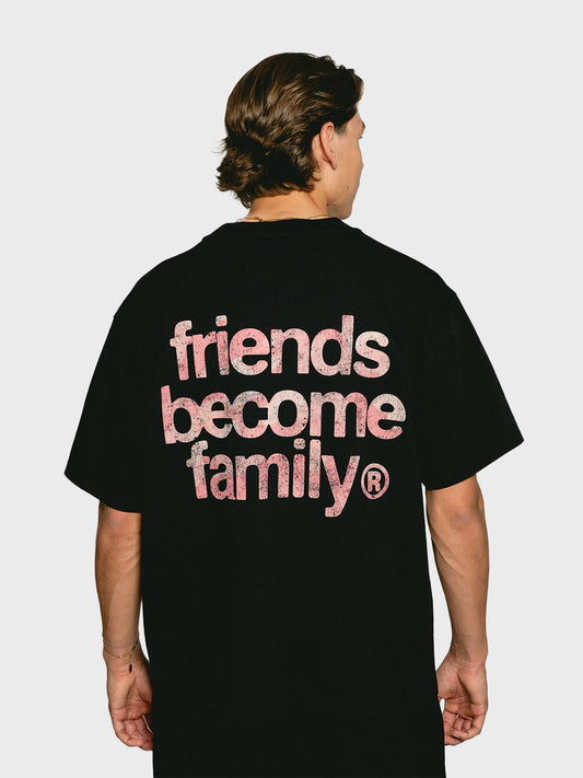 Model draagt Ninetyfour FBF Soft Force T-Shirt Black, achterkant met roze camo 'Friends Become Family' print