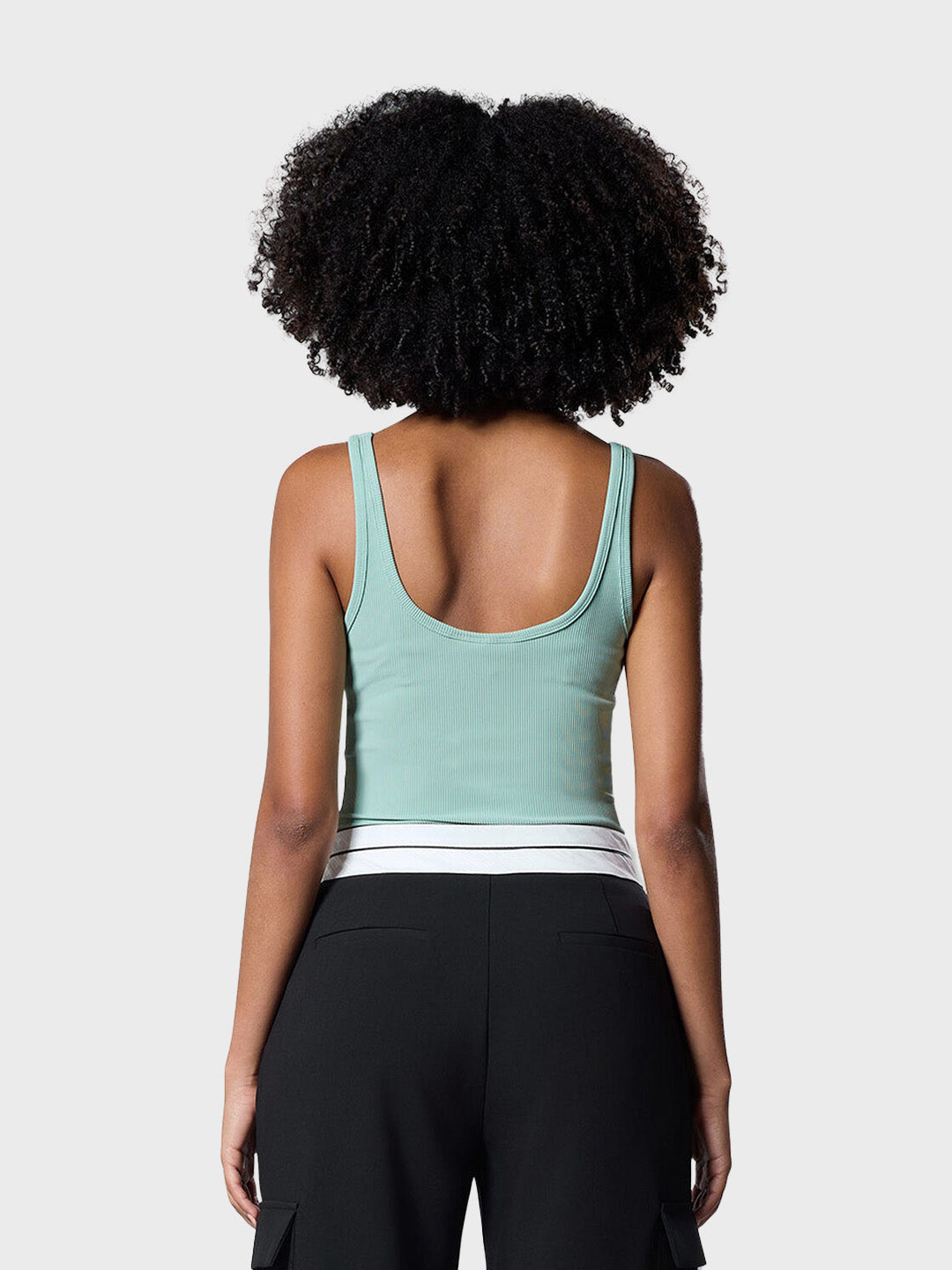 Model draagt lichtgroene ribbed tanktop van Off The Pitch, achterkant