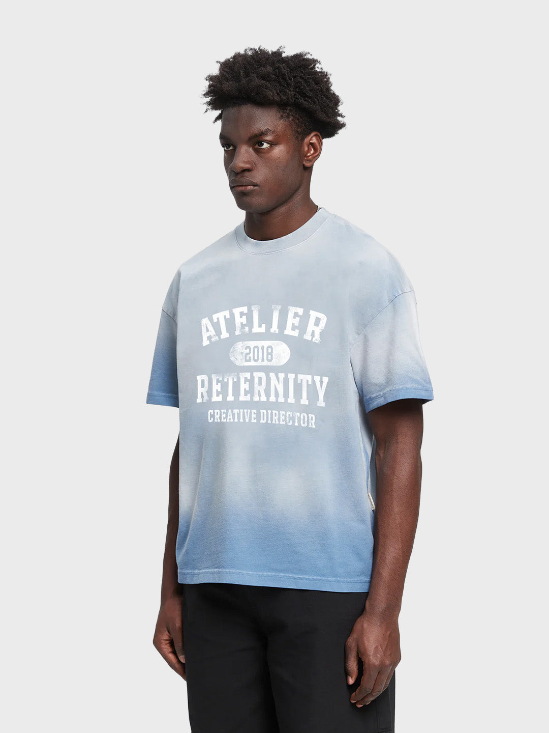 Reternity Atelier Emblem T-Shirt Bleached Blue - model schuin voor
