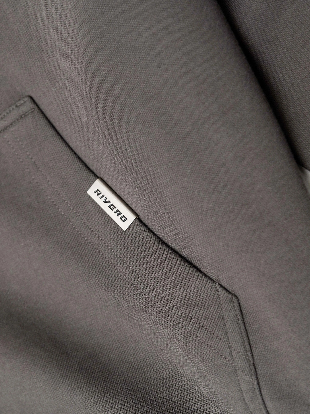 Close-up metalen tag bij zak van Rivero Hoodie