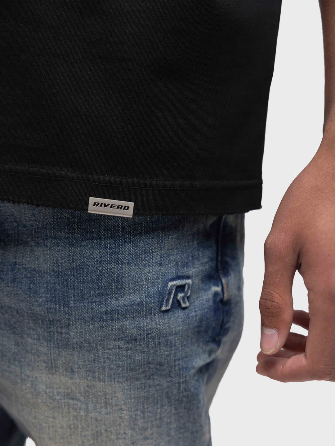 Close-up van metalen Rivero label op het T-shirt