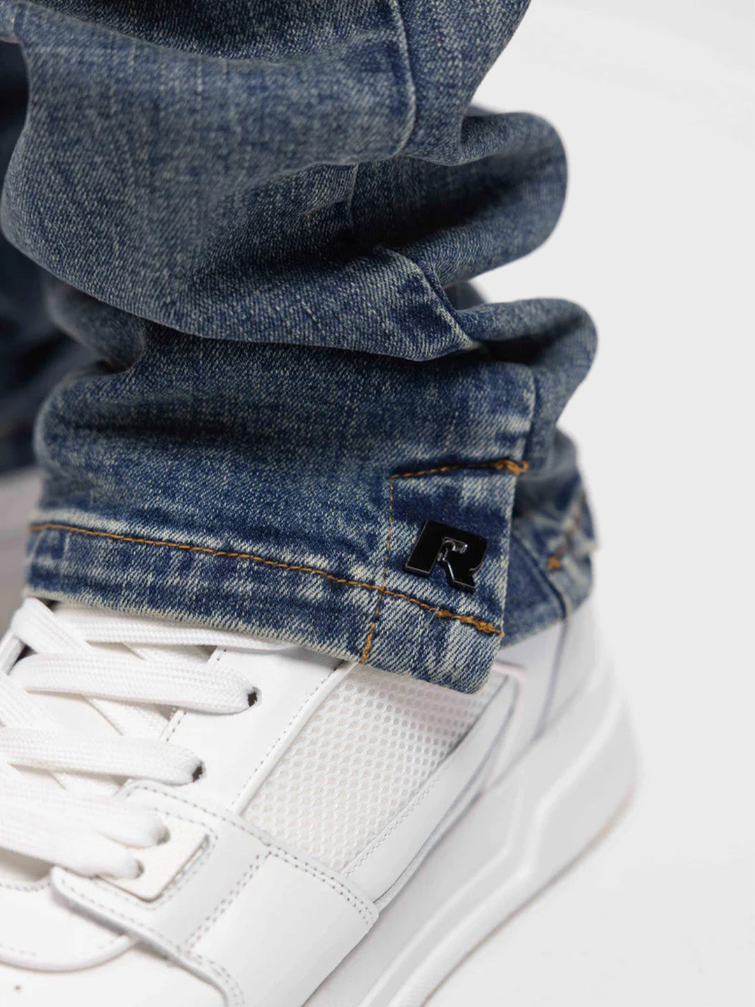 Close-up van knoopsluiting bij de enkel van de jeans